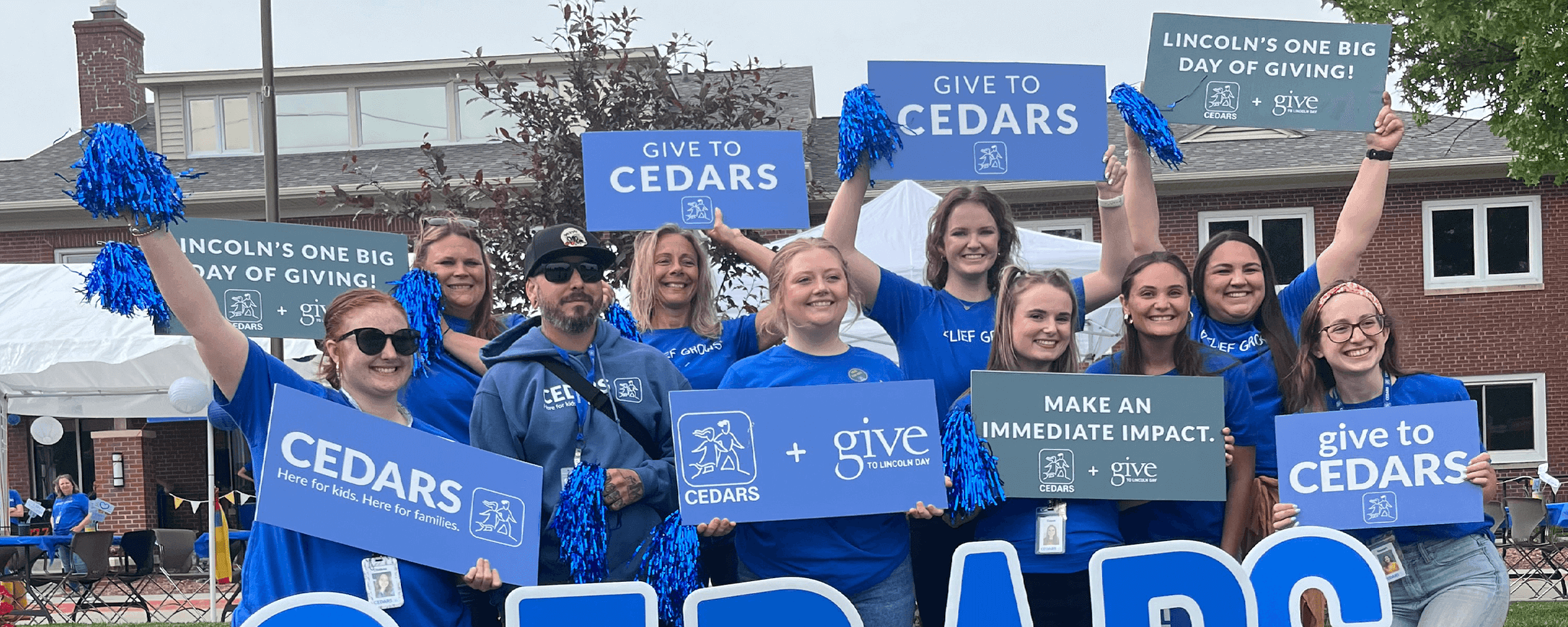 CEDARS employees holding signs outside of CEDARS asking people to support the organization