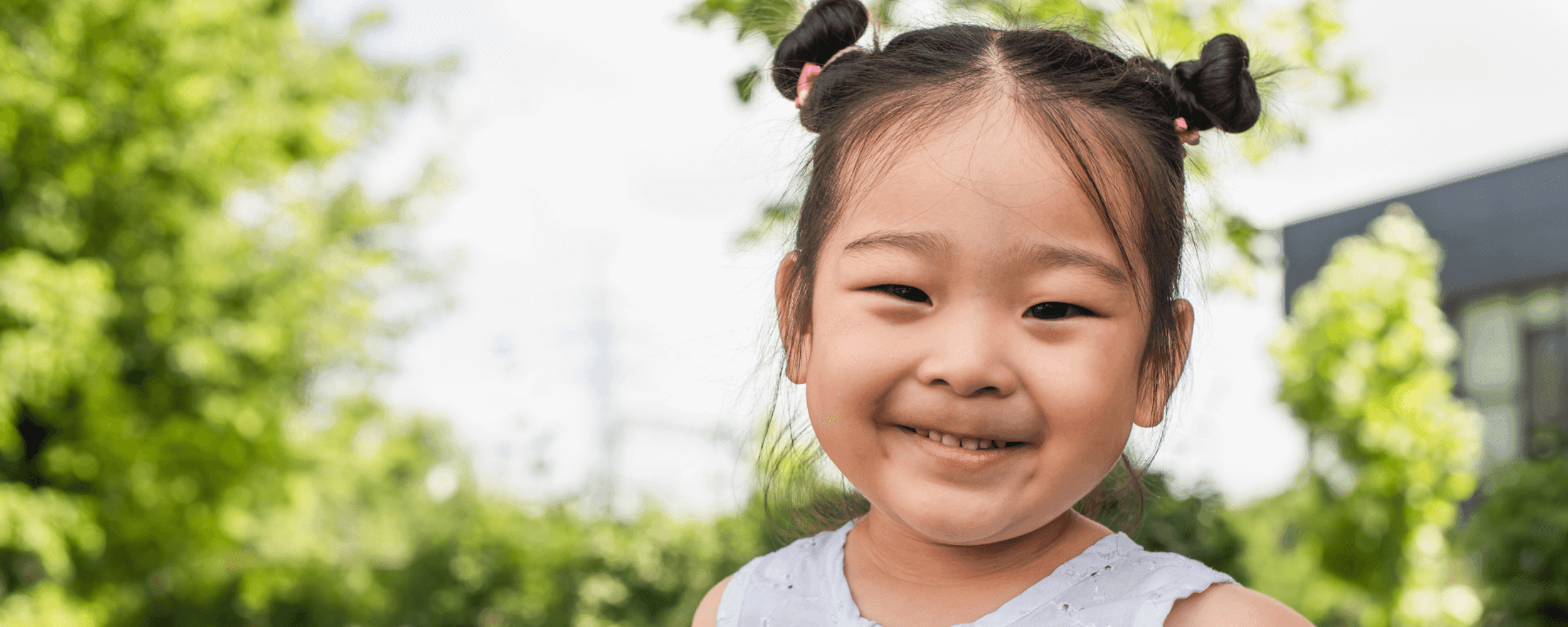 Young girl standing outside and smiling at the camera