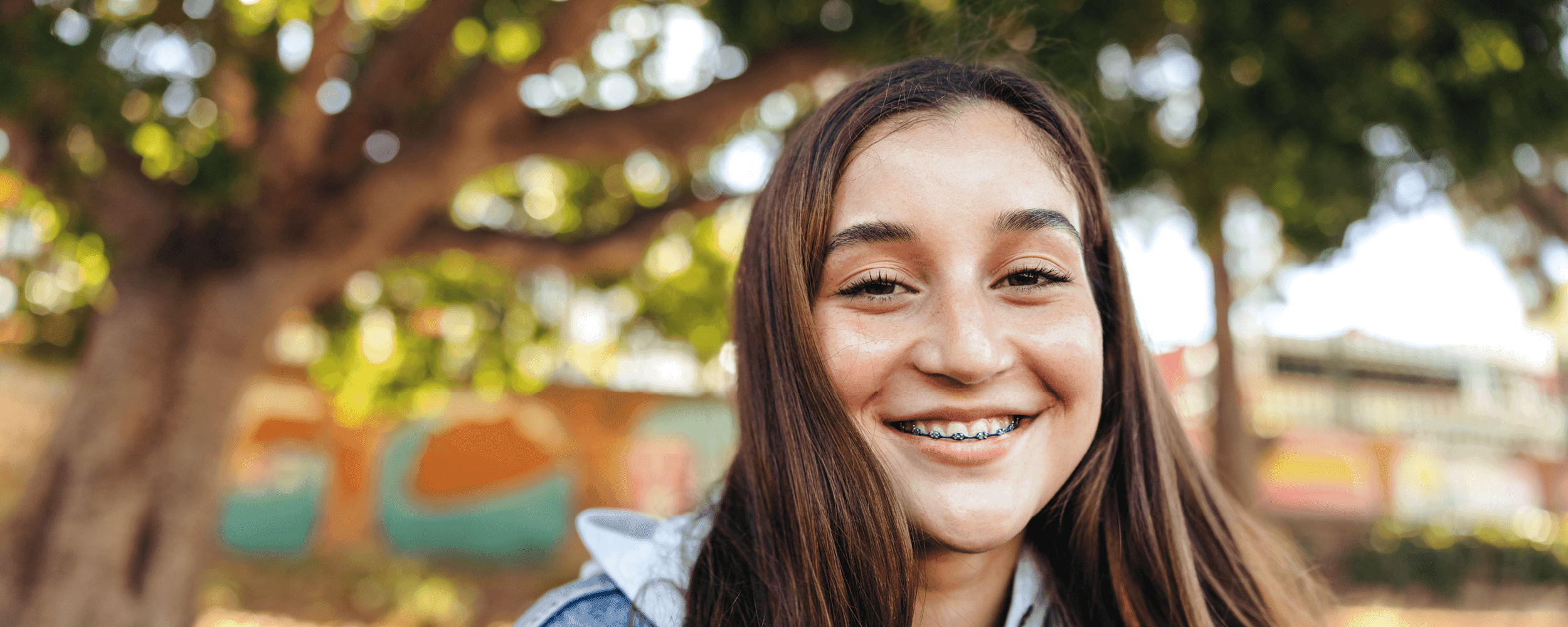 Teen girl standing outside smiling at the camera